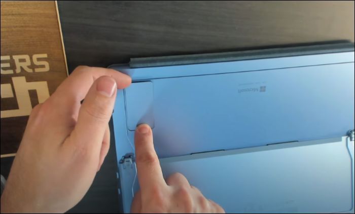 zdejmij pokrywę dysku SSD palcem lub narzędziem do wyjmowania karty SIM